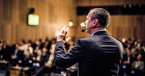 Homme professionnel donnant une conférence dans une salle avec du public. Programme de formation continue de Dauphine Executive Education et Le Cordon Bleu