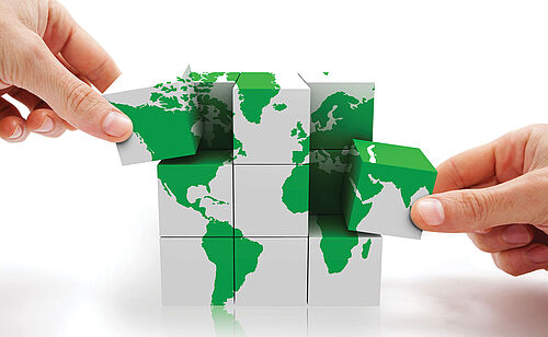 Mains de professionnels avec une planisphère en puzzle symbolisant le Certificat Information Extra Financière : Reporting, Audit et Notation en formation continue  de Dauphine Executive Education (Université Paris Dauphine-PSL) en partenariat avec Asforef