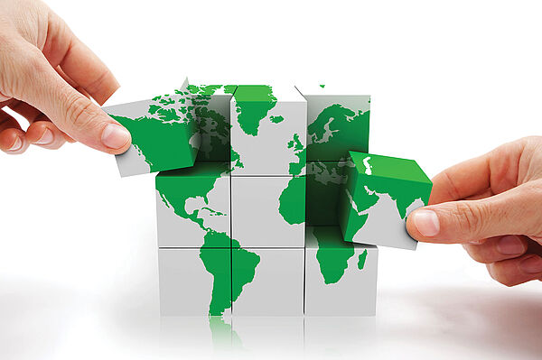 Mains de professionnels avec une planisphère en puzzle symbolisant le Certificat Information Extra Financière : Reporting, Audit et Notation en formation continue  de Dauphine Executive Education (Université Paris Dauphine-PSL) en partenariat avec Asforef